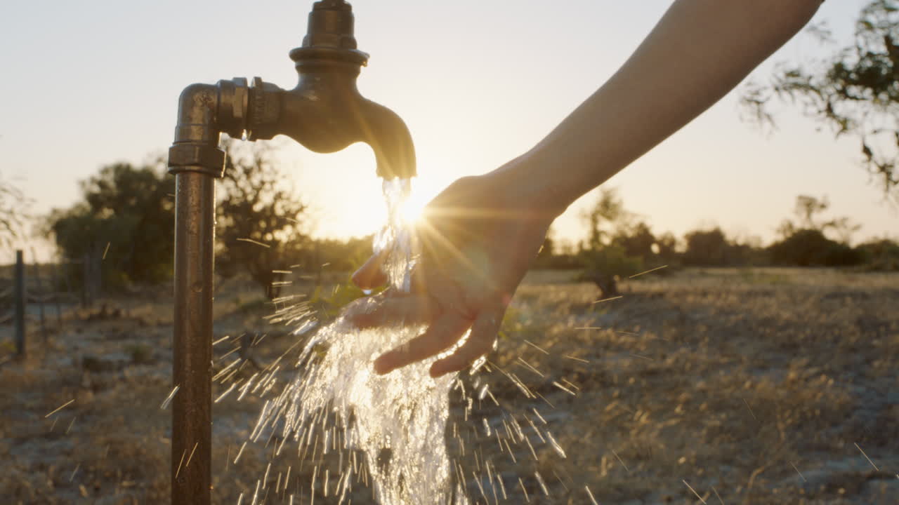 mujer lavando la mano bajo el grifo en una granja rural al atardecer agua dulce que fluye del grifo