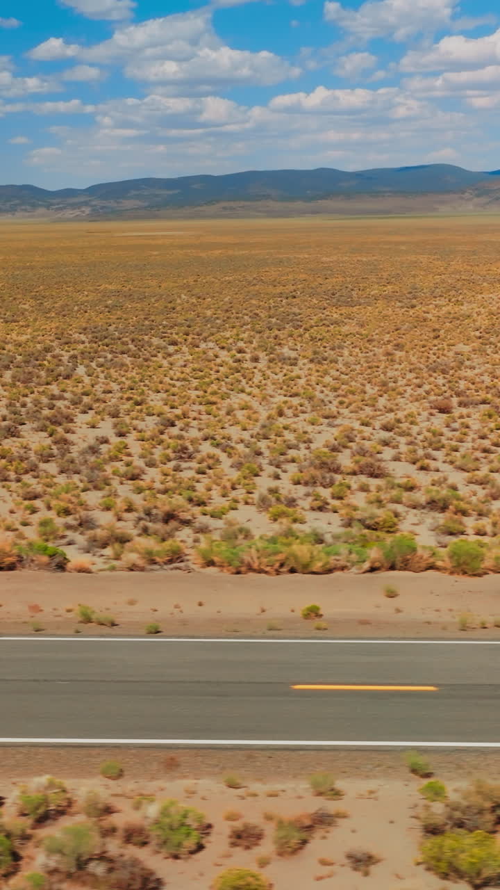 Desert highway car driving. Nevada desert road aerial shot. Vertical video