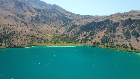 vuelo aéreo hacia atrás paisaje natural de agua dulce del lago kournas, isla de creta - grecia