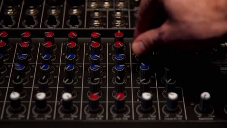 close-up of a person adjusting an audio mixer