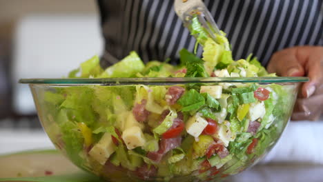 mixing together all the fresh ingredients of a chopped salad - antipasto salad series