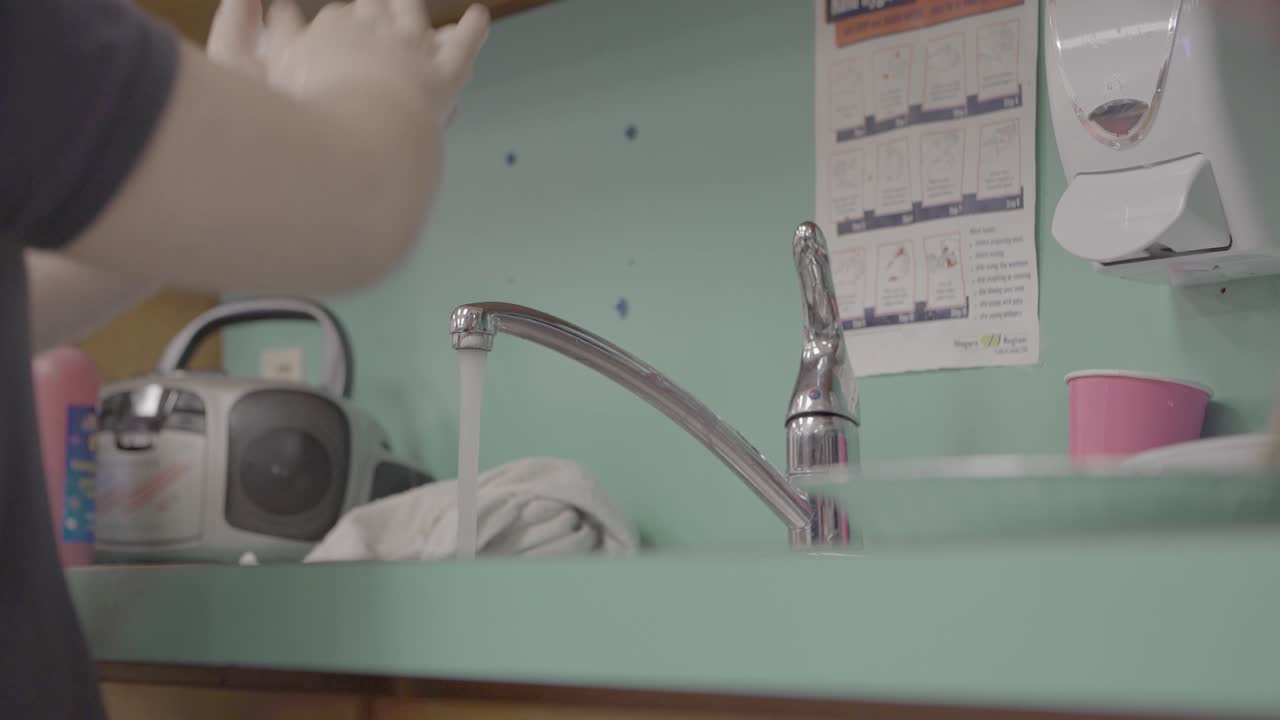 Child and Adult washing hands in a daycare