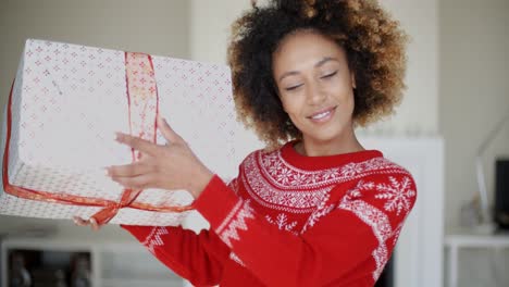 Hermosa-Niña-Agitando-Su-Regalo-De-Navidad-En-Caja