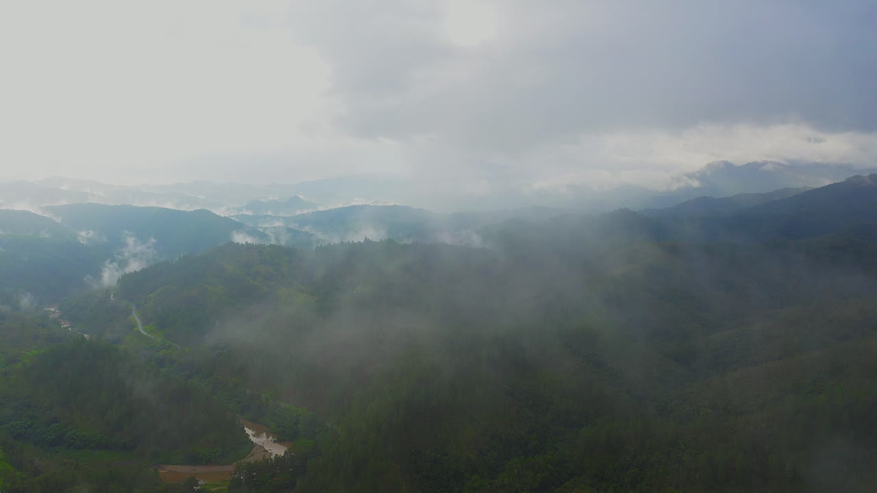 드론 샷은 구름을 통해 활공하여 멋진 열대 산맥을 드러냅니다.