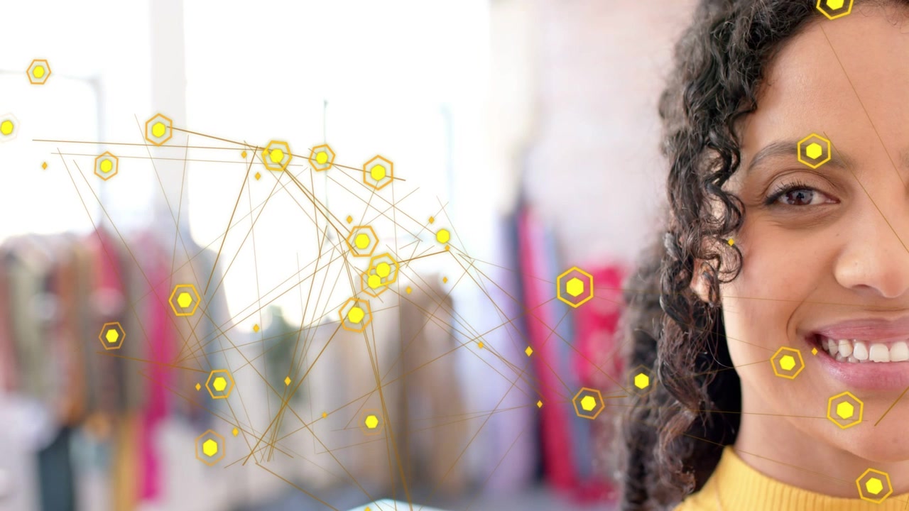 Adult female responding to animated yellow hex nodes drifting across boutique scene with big smile
