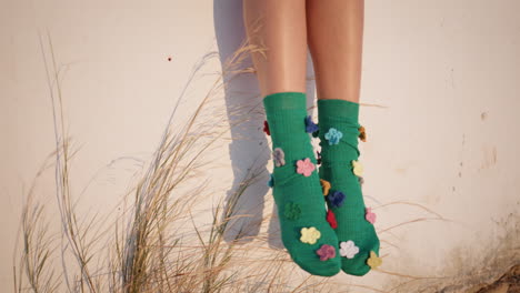 piernas con calcetines coloridos a la luz del sol al aire libre. niño despreocupado disfrutando de la noche