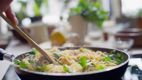 stirring hot spaghetti in skillet