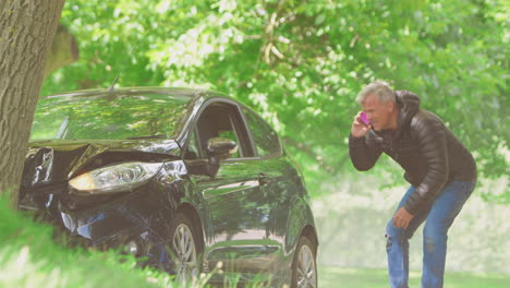 Mature-Man-Gets-Out-Of-Smoking-Car-And-Inspecting-Accident-Damage-Before-Calling-Emergency-Services