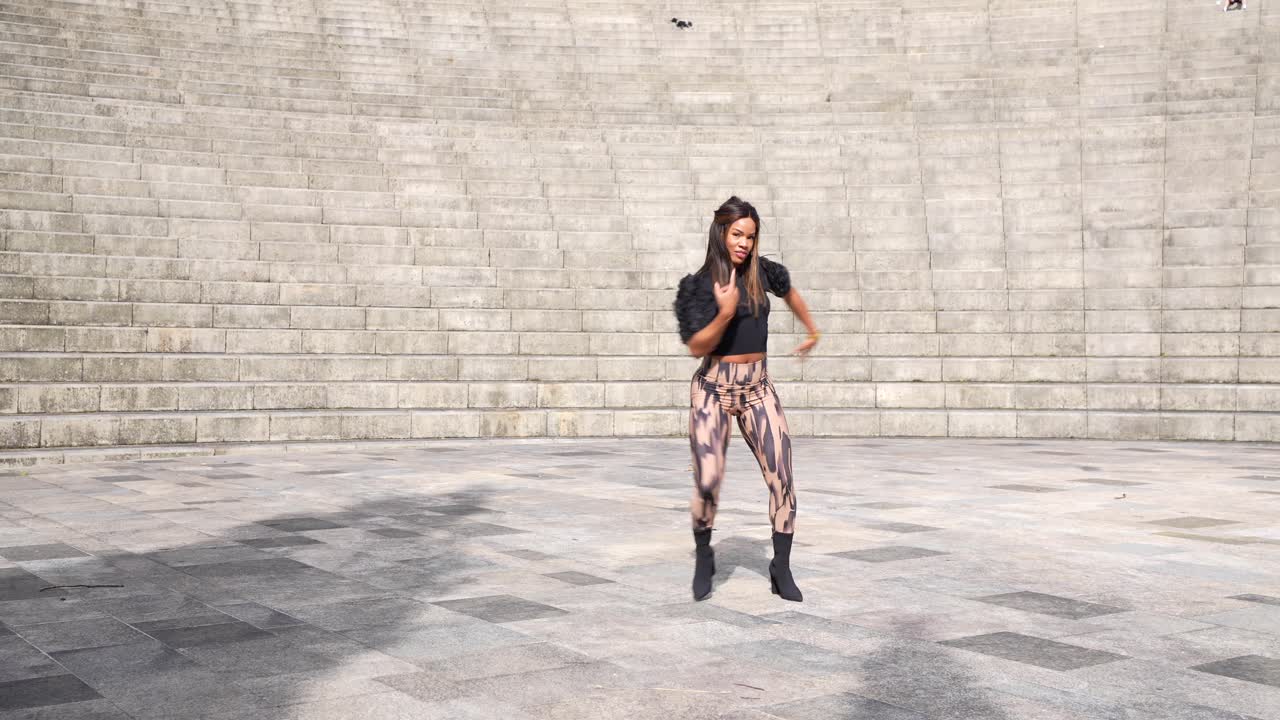 Mujer bailando al aire libre frente a unas escaleras