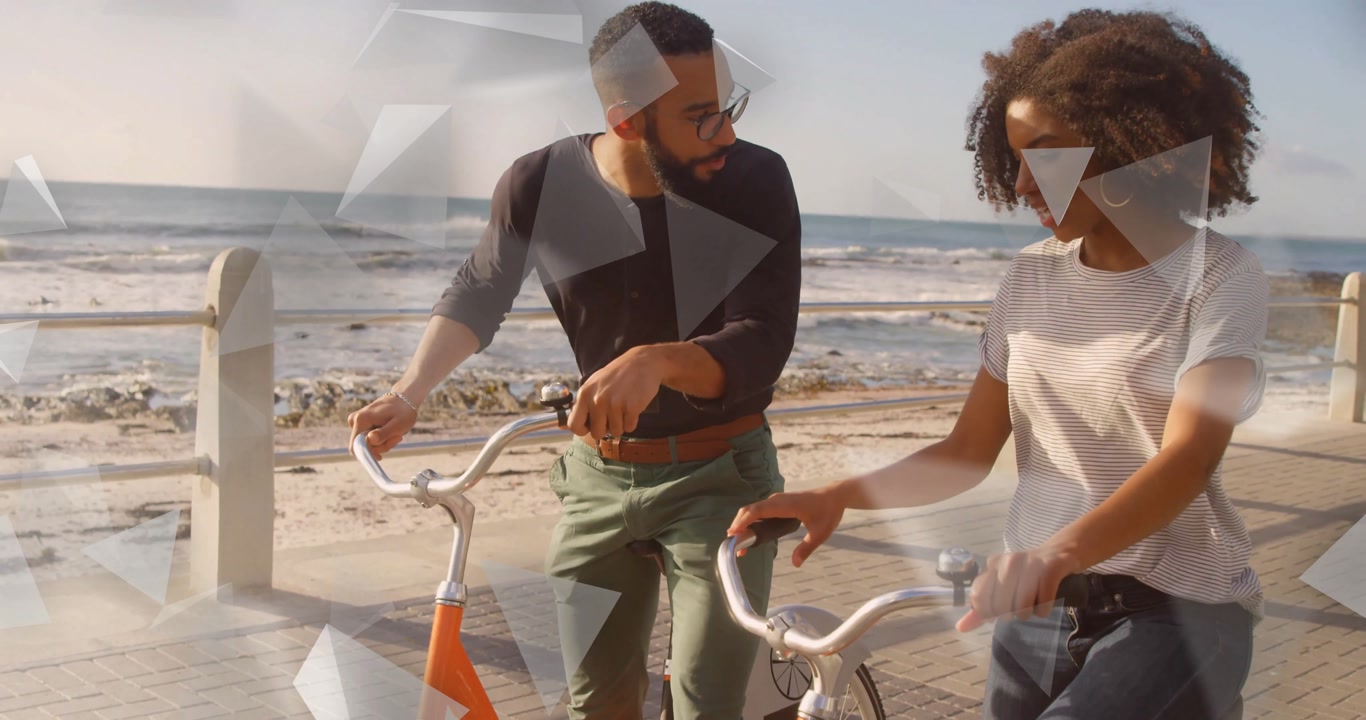 Couple adjusting orange bike grips and shifting weight before starting leisure beachside bike ride