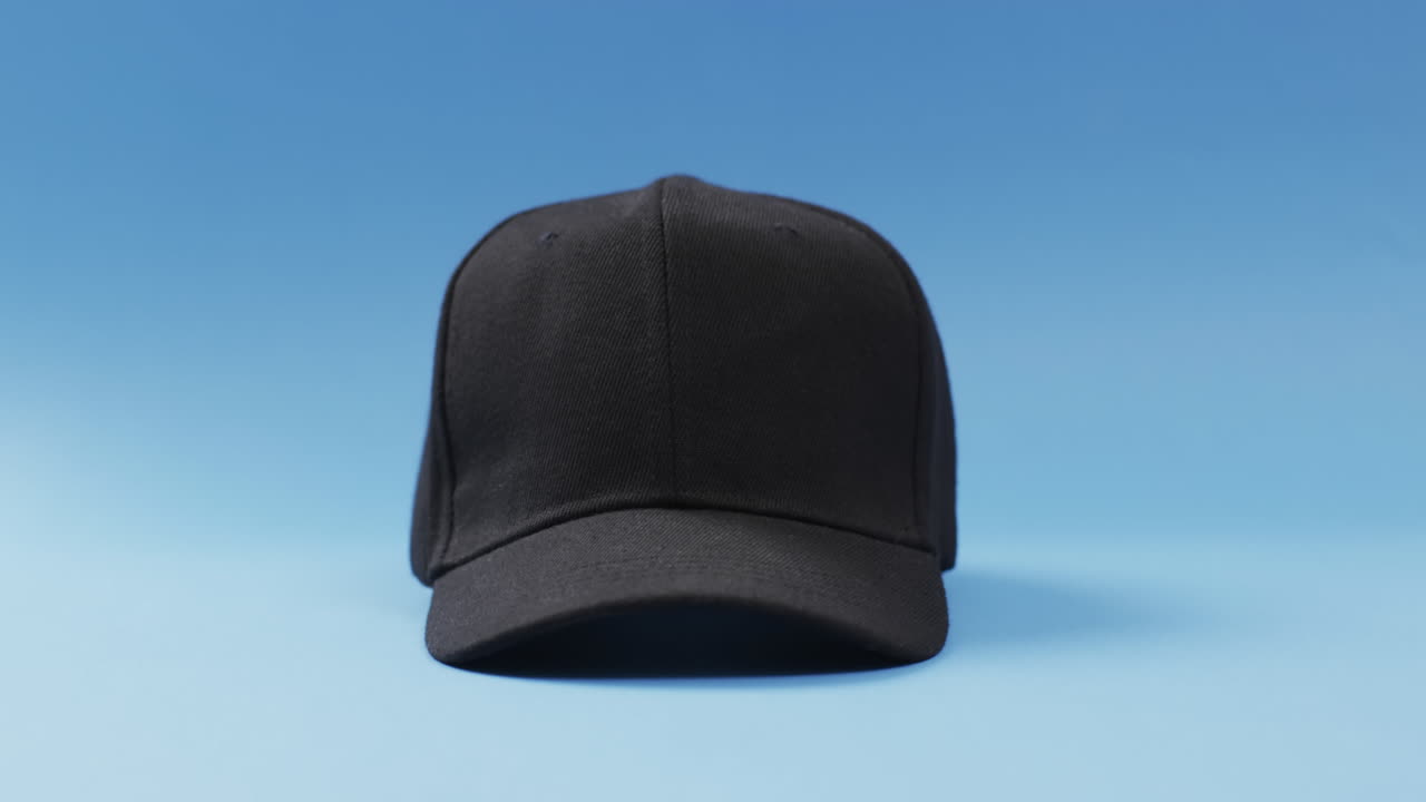 블루 배경 에 있는 검은 야구 모자 와 복사 공간 의 비디오