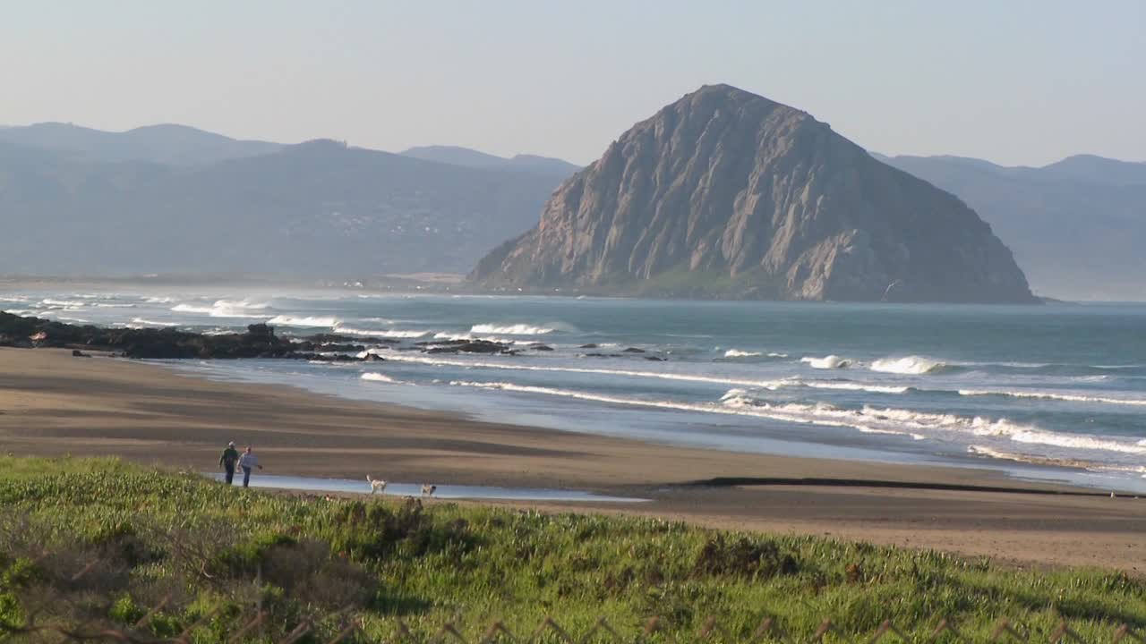 una toma de establecimiento de una gran roca a lo largo de la costa de california cerca de morro bay