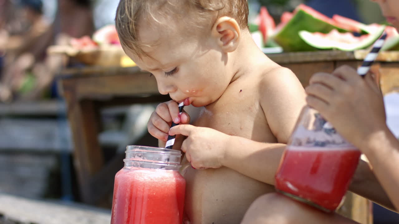 Camera Focuses On A Wet Boy Without Clothes On The Beach While He Drinks A  Watermelon Juice With A Straw Accompanied By His Sister Free Stock Video  Footage Download Clips People