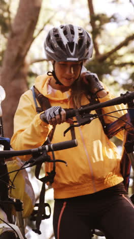 mountain biking couple carrying bicycle and interacting with each other