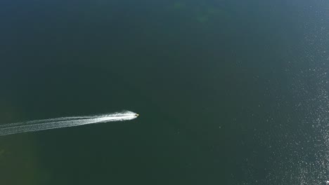 La-Moto-De-Agua-Se-Aleja-De-La-Playa,-Toma-Aérea-De-Gran-Angular