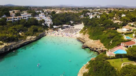 retreating drone shot of the cala anguila cove beachfront, a perfect getaway located in the island of mallorca, off the coast of spain in the mediterranean sea