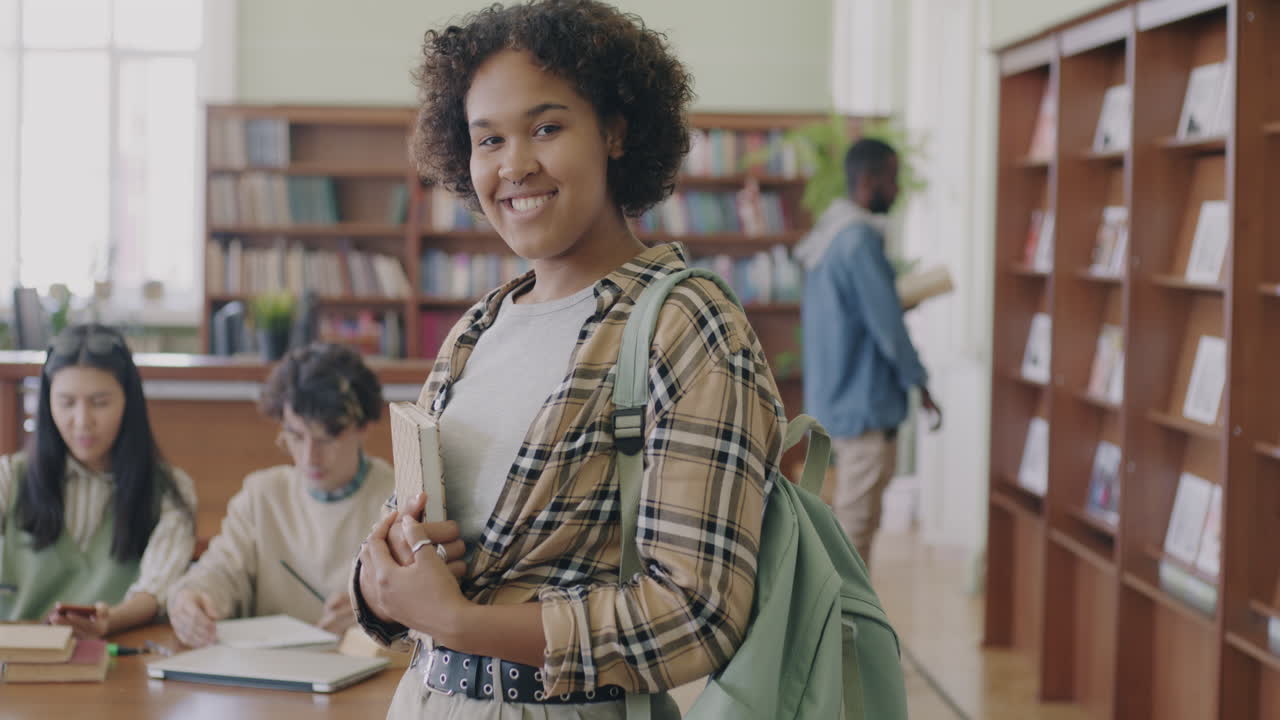 Teenage girl smiles in a library