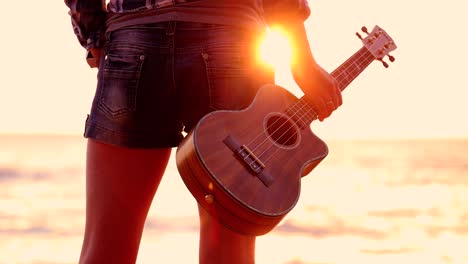 Woman-at-sunset-holding-a-ukulele