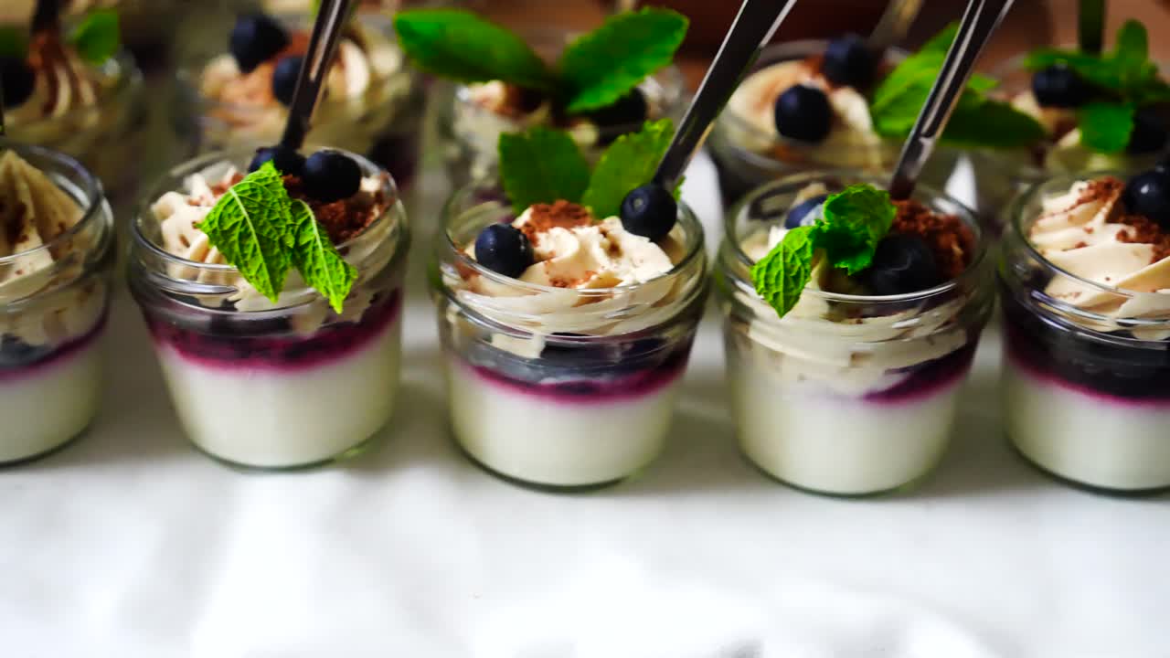 mousse de yogur con salsa de arándanos postre con cuchara de metal en frasco de vidrio