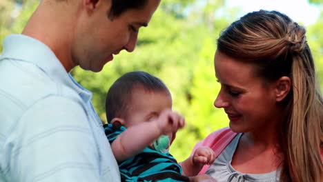 Proud-parents-holding-baby-son-in-the-park