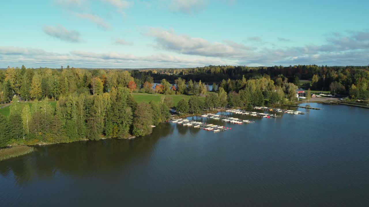 Golden hour flyover of northern boreal lake marina in Scandinavia