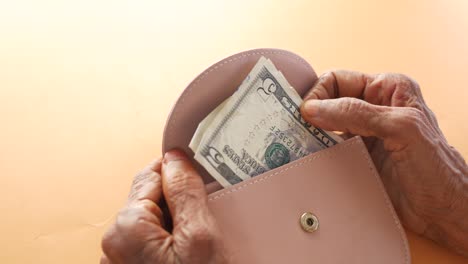 Senior-women-hand-saving-cash-in-wallet