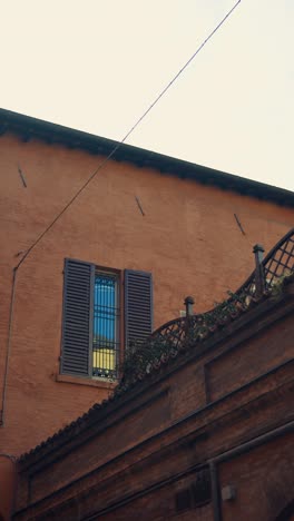 old italian building exterior with a window and shutters