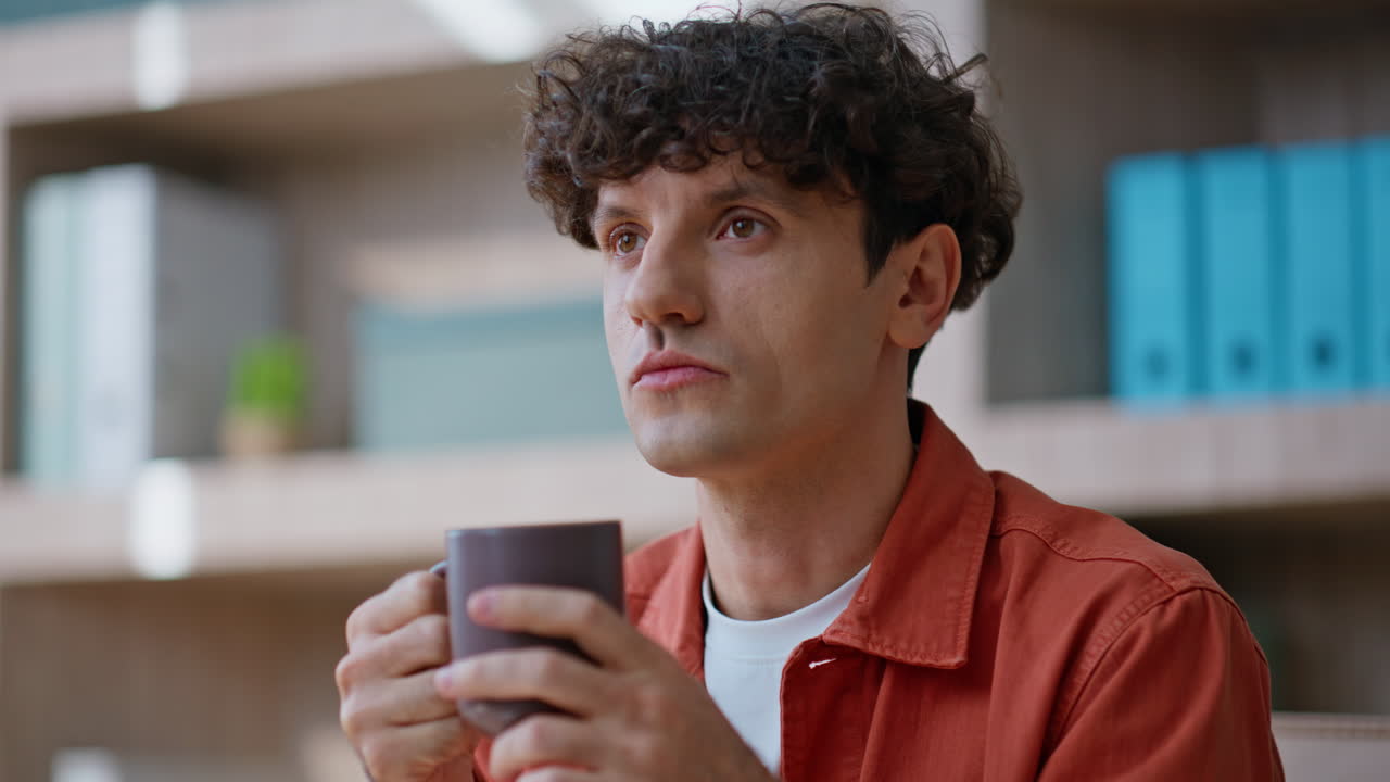 Thoughtful freelancer drinking tea at distant workplace closeup. Portrait man