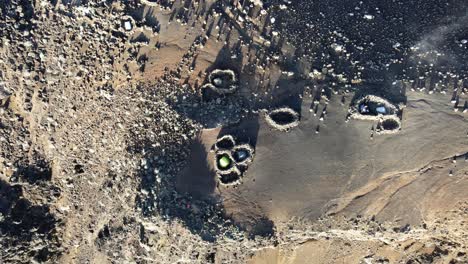 close top-down drone footage of tent in rocks circle on the summit of the piton des neiges at the reunion island