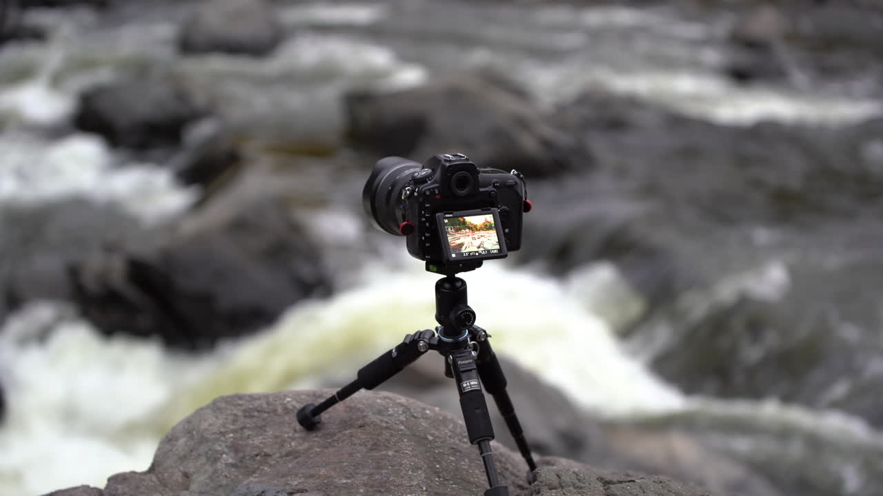 Camera on a tripod taking pictures of a river