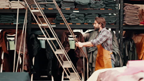 man, textile factory and ladder to shelf at job