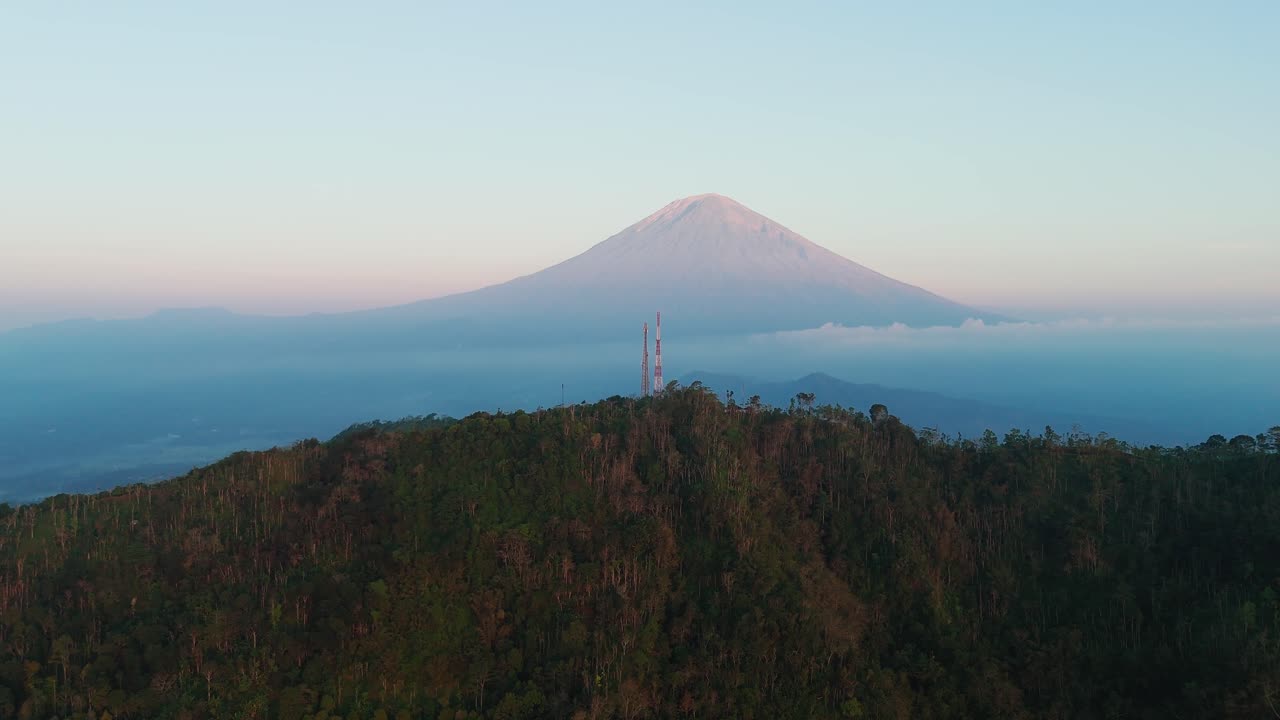 Immagine aerea del vulcano Monte Agung e delle colline boscose a Karangasem, Bali, sotto la luce del sole tropicale