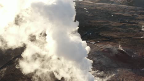 orbit shot around tower of white steam rising from geyser with bright sunlight