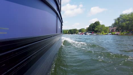 low waterline shot of pontoon boat slowly cutting through the water