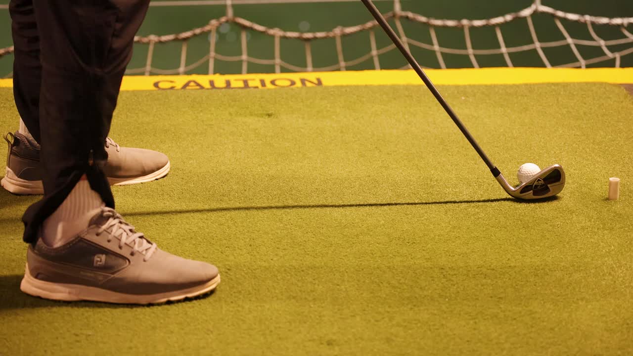 Un golfista esegue uno swing e colpisce una palla