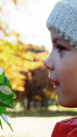 girl blowing toy with parents in background