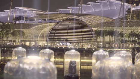 floating apple store at marina bay sands from the shine a light installation with light beams projecting from the promontory at night in singapore. - wide shot