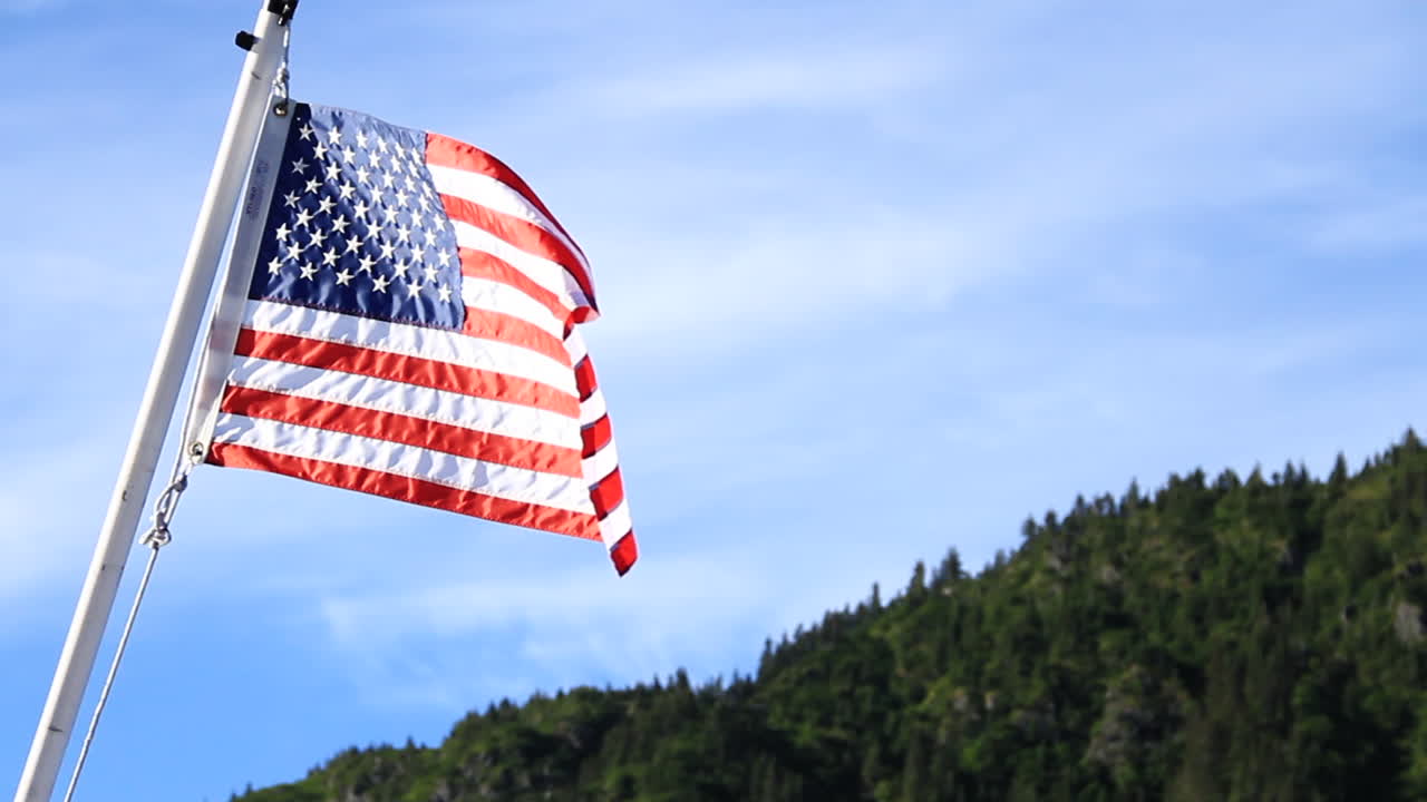 America Flag Waves in Wind with Beautiful Blue Sky