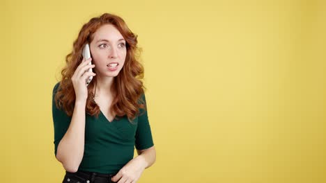 surprised redhead woman talking on a phone call with a yellow background