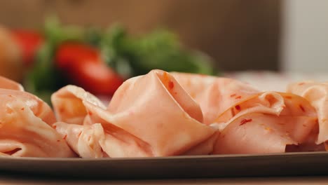 ham italian mordatella, man slices of traditional italian antipasti mortadella sausage on a wooden cutting board, close up macro of chicken or turkey jamon, fat breakfast dish.
