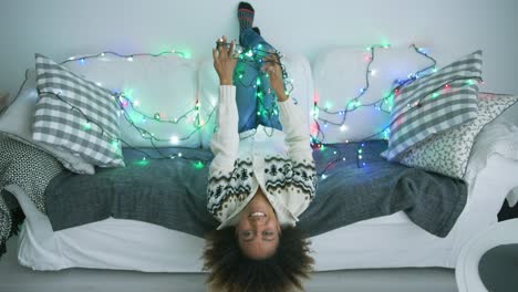 Smiling-woman-on-sofa-with-twinkle-lights