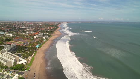 Batu-Belig-Beach-Coastline-with-Long-White-Foamy-Waves-Rolling-Over-Soft-Sand-In-Bali-Indonesia---Bird's-Eye-Aerial-Pull-Back-Along-Coastline