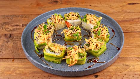 closeup-of-a-plate-of-avocado-sushi-being-removed-from-a-wooden-table-in-a-restaurant