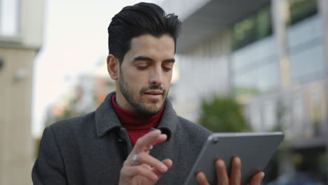 man using a tablet on the street