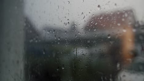 Close-up-of-raindrops-hitting-a-window-during-a-thunderstorm