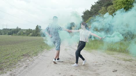 pareja con humo de colores dando vueltas por el camino polvoriento