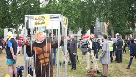 a trump protester dressed up in a gorilla costume with donald trump mask in a cage at the together against trump protest in central london.