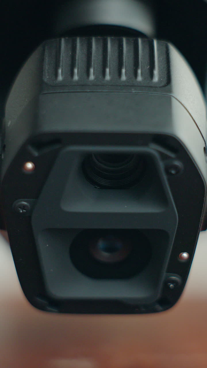 Primo piano dell'obiettivo di una fotocamera per drone con meccanismo gimbal che si muove su e giù, dettaglio di moderna tecnologia aerea con focus sulla stabilizzazione e l'ottica.