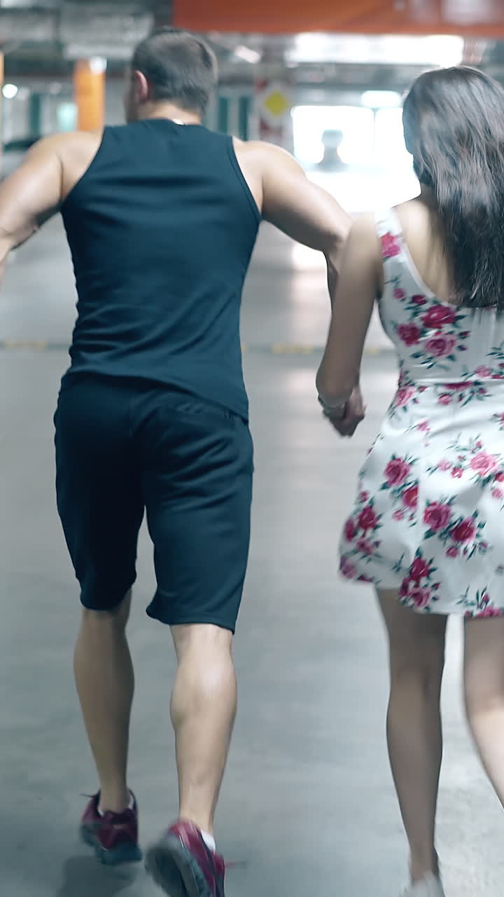 Couple Running Through an Underground Parking Garage