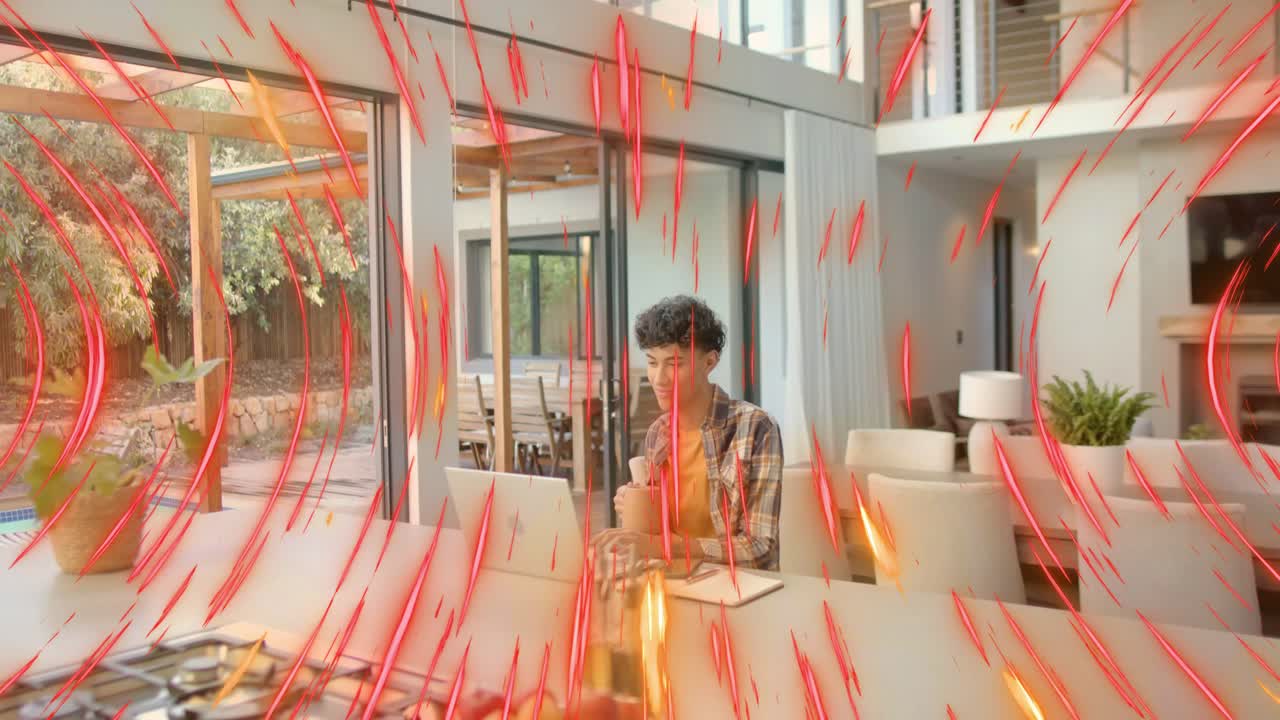 Man doing remote work on laptop while sipping cup at island, red-orange streaks appearing over him
